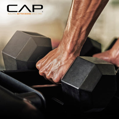 Action shot of training with hex dumbbells with rack from the CAP Barbell set.