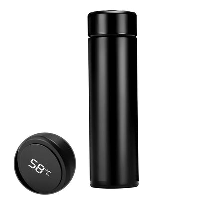 The LED Temperature Display Thermos Bottle placed on a desk next to a laptop.